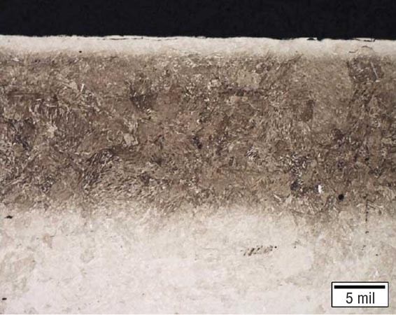 氮化合金組件的金相圖，具有均勻的滲氮層，深度約為0.40毫米（0.016英寸），并且沿表面明顯有淺白亮層。